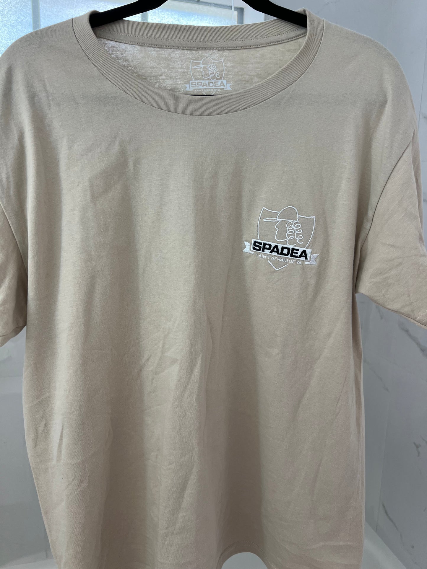 Beige tshirt logo shield